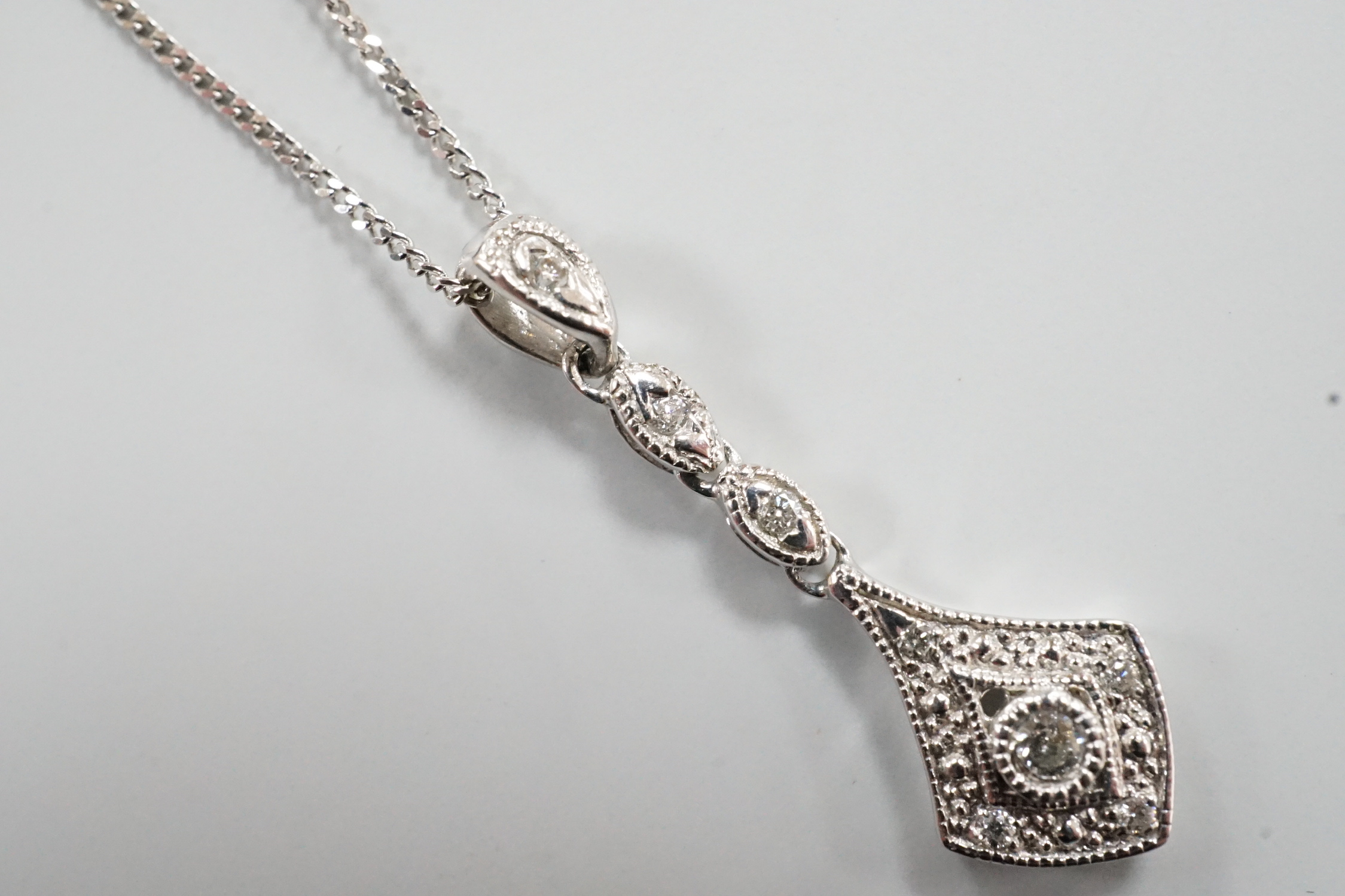 A modern 375 white metal and diamond chip set drop pendant, 23mm, gross 0.6 grams on an 18ct white gold chain, 46cm and one other 18ct white gold chain, 40cm, 18ct gross 2.9 grams.